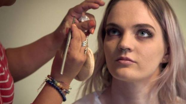 Una mujer maquillando a Jade para una escena.