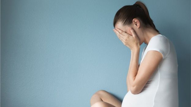 Una mujer embarazada llorando