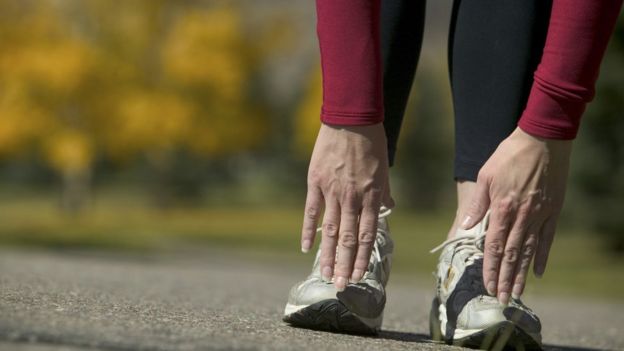 Mujer se toma los dedos de los pies.