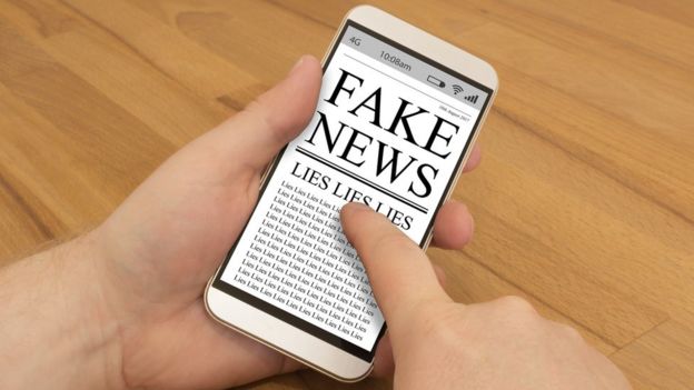 Pantalla de un teléfono móvil con una referencia a las noticias falsas y las mentiras