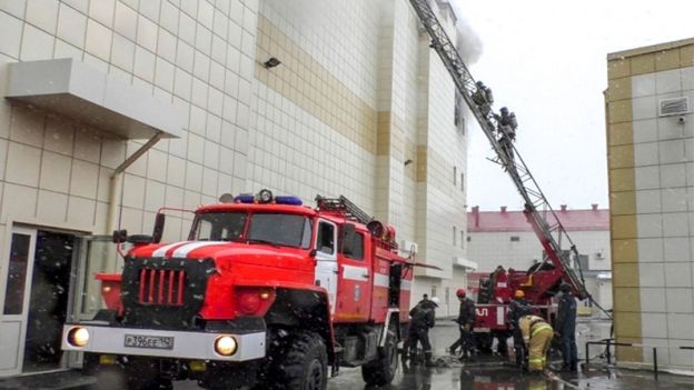 Bomberos suben escaleras para alcanzar el incendio