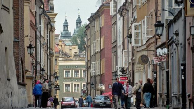 بعض المارة والسيارات في أحد شوارع وارسو