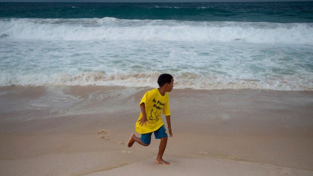 Boy from a favela during a demonstration demanding for peace in Copacabana beach