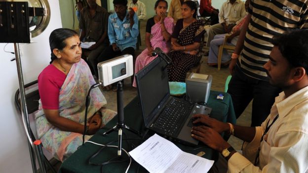 An Indian villager looks at an Iris scanner during the data collecting process for Aadhaar.