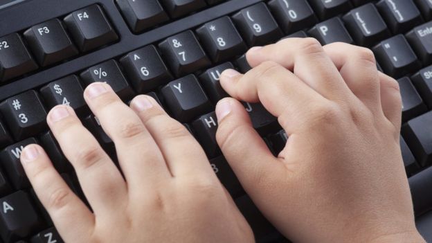 Criança digitando no teclado