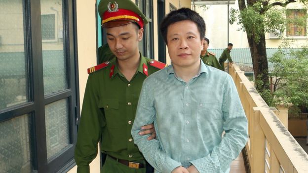Image shows Ha Van Tham being led to court