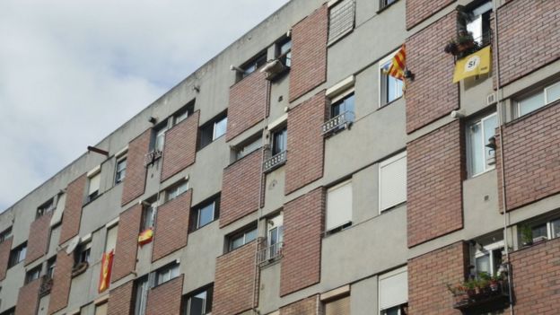 Banderas de España y de Cataluña cuelgan de ventanas en un conjunto residencial de Ciutat Meridiana.