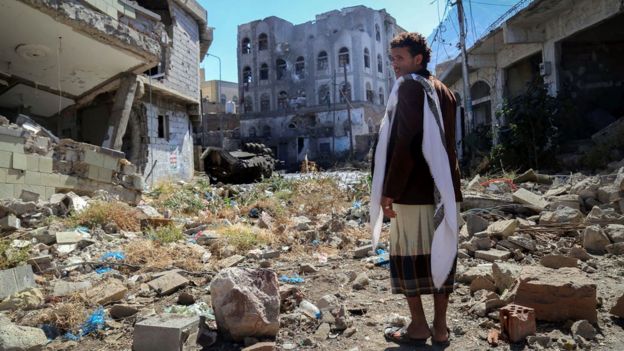 A Yemeni man inspects the damage on a street following clashes between pro-government militiamen and Houthi rebels in Taiz (22 November 2016)