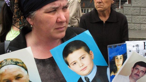 Relatives of Beslan siege victims stand outside court with portraits on 17 May 2005