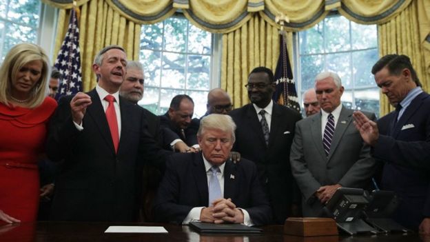 .S. President Donald Trump, Vice President Mike Pence and faith leaders say a prayer during the signing of a proclamation in the Oval Office of the White House September 1, 2017 in Washington, DC