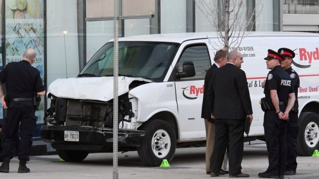Investigators view a damaged van seized by police after multiple people were struck at a major junction in northern Toronto, April 23, 2018
