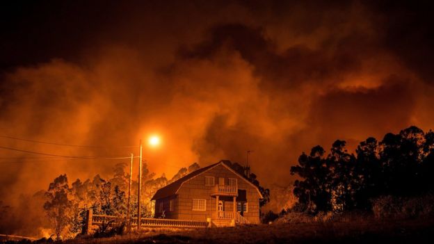 El fuego arde cerca de una casa en Nigrán, Galicia