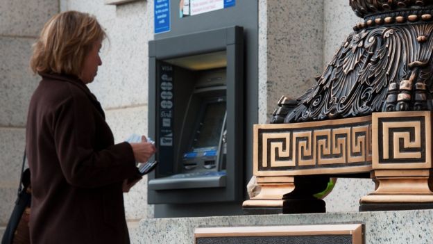 Una señora saca dinero de un cajero de Bank of America