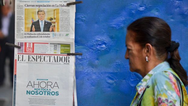 Una señora pasa por un quiosco de prensa en Colombia