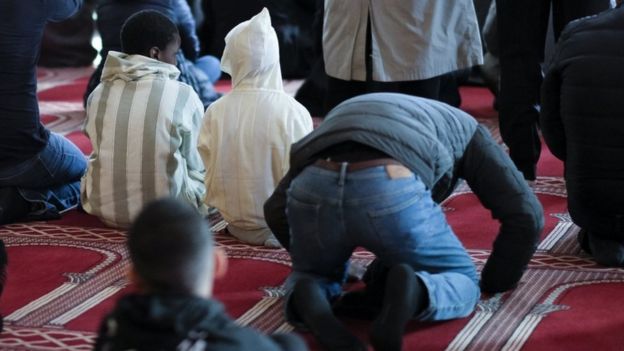 Hombres rezando en una mezquita.