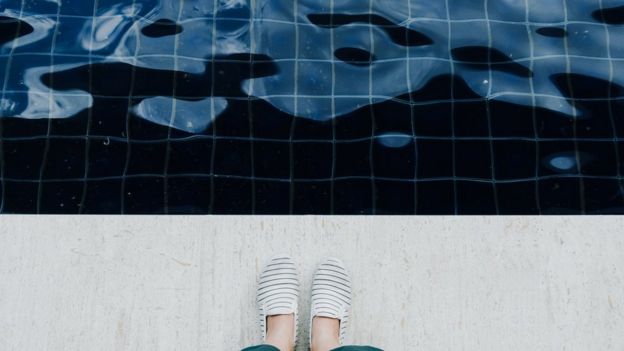 Pessoa na beira de uma piscina