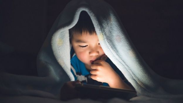 niño usando teléfono móvil