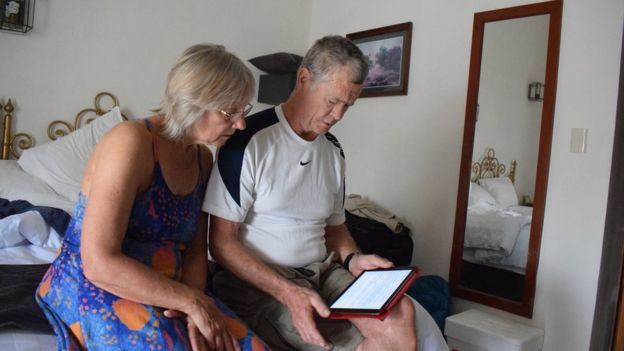 Dos turistas ven internet en su tablet.