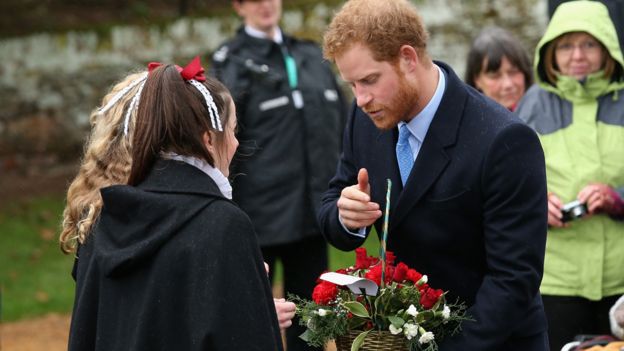 Prince Harry receiving flowers on a church visit on Christmas Day in 2015