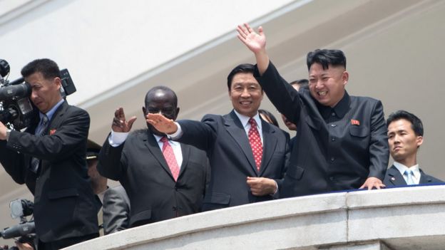Kim Jong-un acena para a multidão em Pyongyang, ao lado de autoridades