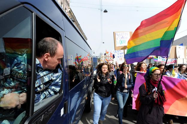 A Russian policeman watches a rally by LGBT activists, 1 May 15