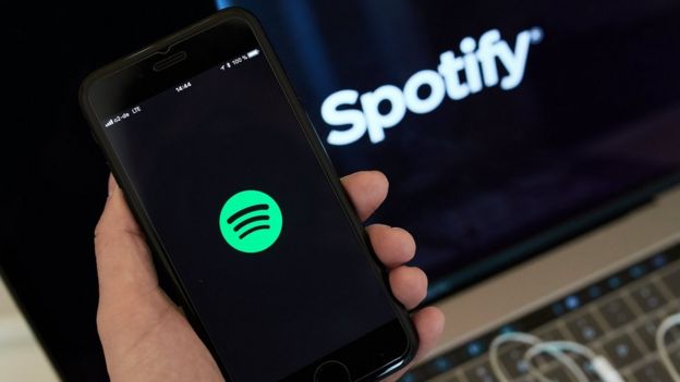 Una persona sostiene un mÃ³vil con la app de Spotify