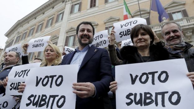 Northern League leader Matteo Salvini (C), holds a placard that reads 