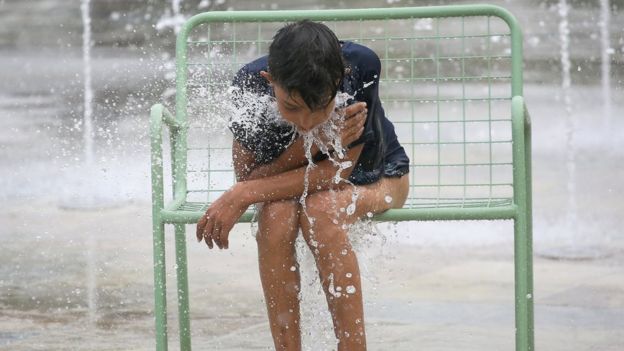 Ayoung Albanian rests after playing in a fountain during a heatwave in the main square in Tirana, Albania, 3 August 2017