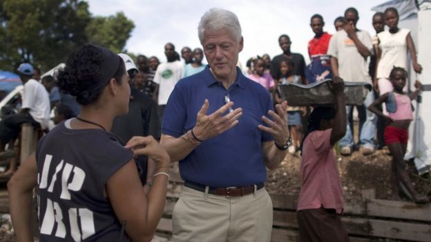 UN special envoy to Haiti, Bill Clinton (C) talks with an NGO worker in Port-au-Prince, Haiti, on 6 October 2010