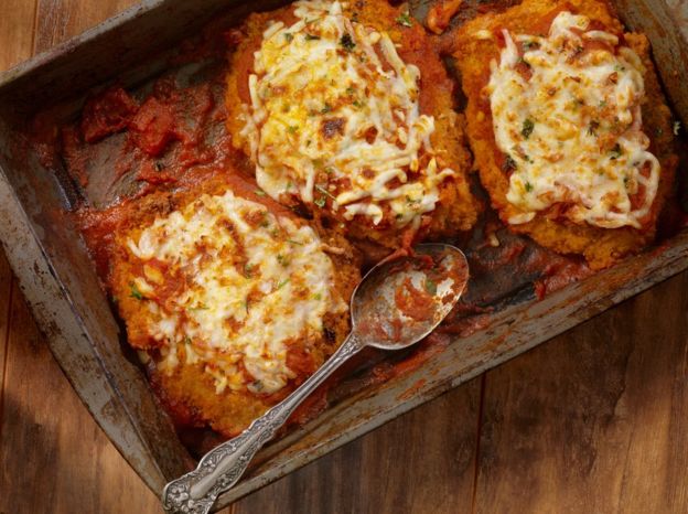 Filetes de pollo empanizados, con tomate y queso.