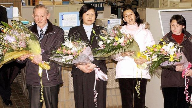 US army deserter Charles Jenkins (L), accompanied by his wife Hitomi Soga (2nd L) and daughters Mika (2nd R) and Brinda (R), receives flower bouquets upon his arrival at Sado island in Niigata prefecture, 300km north of Tokyo, hometown of his Japanese wife Hitomi Soga as he left a US base 7 December 2004.