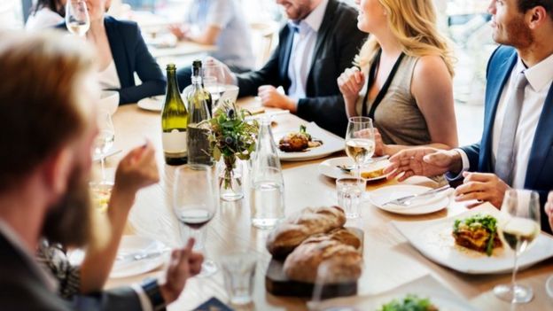 Personas sentadas a la mesa en un restaurante