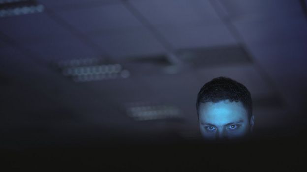 Hombre mirando a la pantalla de una computadora.
