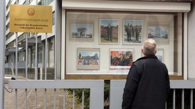 Một du khách xem tranh ảnh cổ động trên bảng tin bên ngoài Đại sứ quán Bắc hàn tại Berlin.