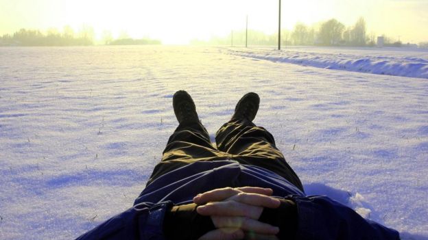 Un hombre descansa acostado en la nieve