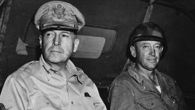 El general MacArthur, con otro militar, a bordo de un jeep.