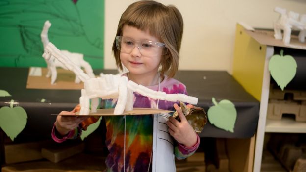 Niña jugando con un dinosaurio