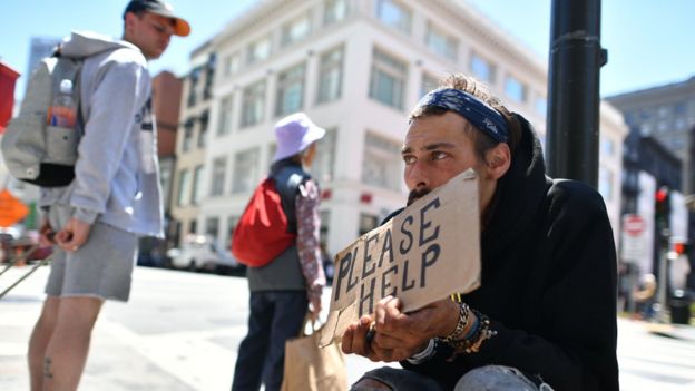 Un hombre sin hogar pide ayuda en una calle en San Francisco.