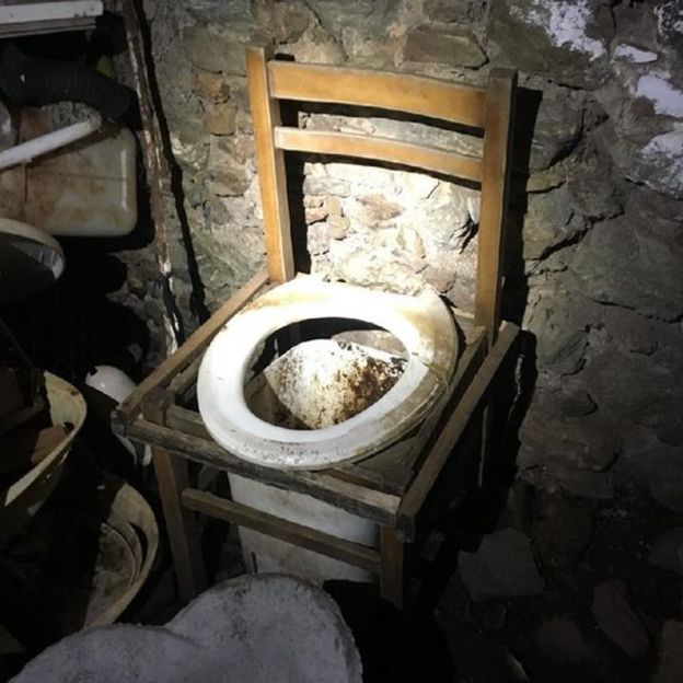 O 'banheiro' era um balde colocado em baixo de uma cadeira | Fonte: Polícia italiana