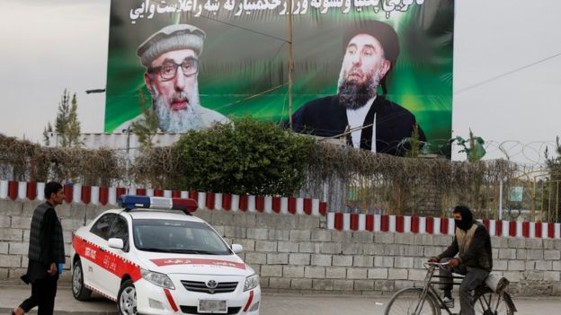 An Afghan man rides on his bicycle past a banner with pictures of Afghan warlord Gulbuddin Hekmatyar in Kabul, Afghanistan on 2 May 2017