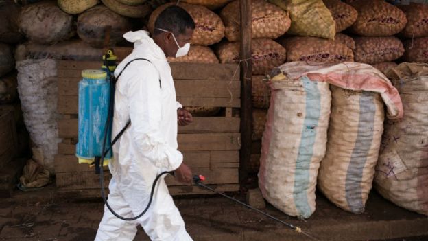 Hombre con traje protector desinfectando en Madagascar.