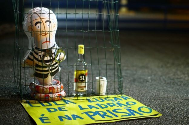 Pictured: A balloon depicting Lula as an inmate, and a sign reading "Lula, the place for a thief is prison."