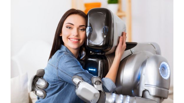Una mujer abrazando un robot