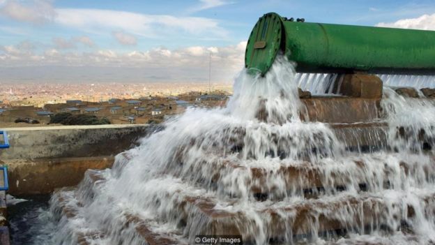 Una tubería gigante deja caer agua en un pozo en una planta de tratamiento