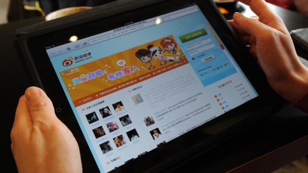 A woman views the Chinese social media website Weibo at a cafe in Beijing
