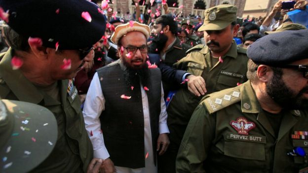 Hafiz Saeed is showered with flower petals as he walks to court before a Pakistani court ordered his release from house arrest in Lahore