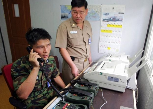 This file photo taken on August 10, 2005 shows South Korean Lieutenant Choi Don-Rim (L) communicating with a North Korean officer during a phone call at a military office near the Demilitarised Zone (DMZ), separating North and South Korea, in Paju, north of Seoul, as the two countries tested a hotline aimed at helping avoid naval confrontations in the Yellow Sea.