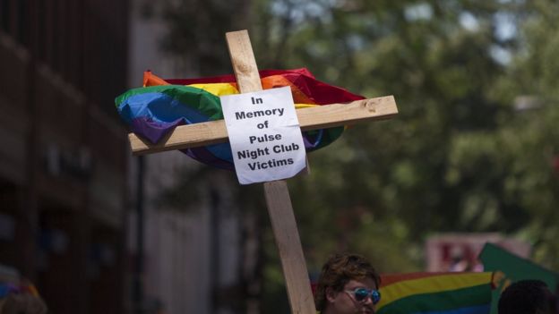 Una cruz con la bandera gay y la inscripción: 