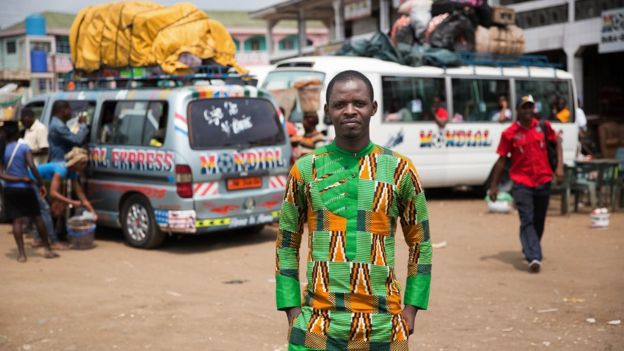 Achiri Arnold Nji stands at a bus terminal in Douala, Cameroon.