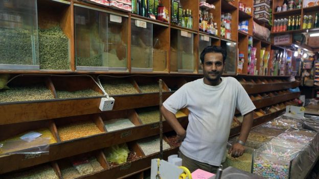 عامل وافد يقف في متجر بالسعودية